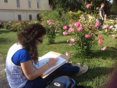 Una studentessa dell'Accademia mentre disegna una rosa 